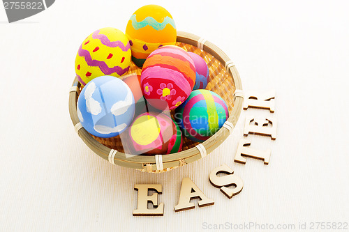 Image of Easter egg in basket with wooden text