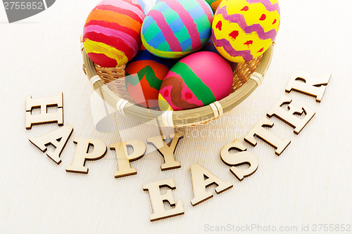 Image of Painted easter egg in basket with wooden text 