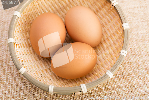 Image of Brown egg in basket over linen background