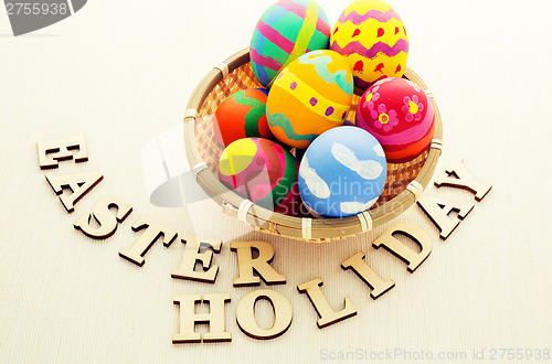 Image of Easter egg in basket with wooden text