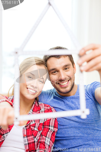 Image of smiling couple with house from measuring tape