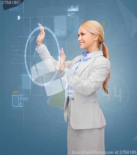 Image of smiling businesswoman working with virtual screen