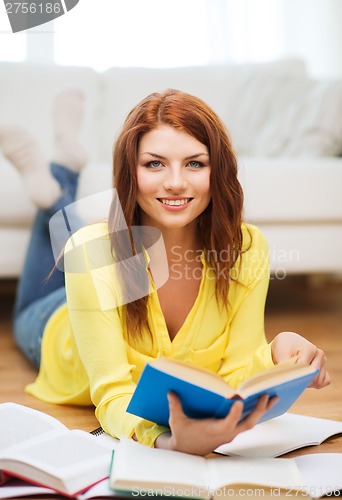 Image of smiling student girl reading books at home