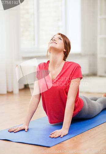 Image of smiling teenage girl streching at home