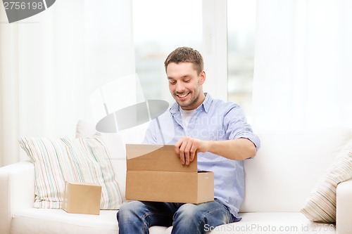 Image of man with cardboard boxes at home