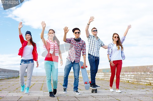 Image of group of smiling teenagers waving hands