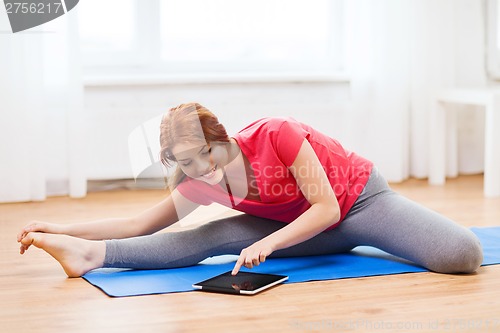 Image of smiling teenage girl streching on floor at home