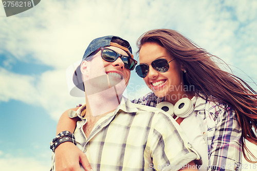 Image of smiling teenagers in sunglasses having fun outside