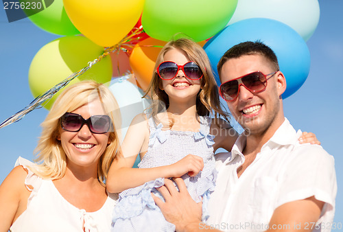 Image of happy family with colorful balloons outdoors