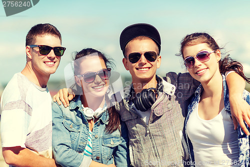 Image of smiling teenagers in sunglasses hanging outside