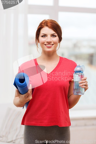 Image of smiling girl with bottle of water after exercising