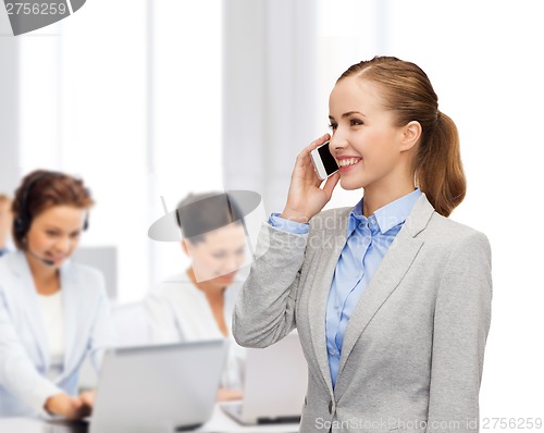 Image of young smiling businesswoman with smartphone