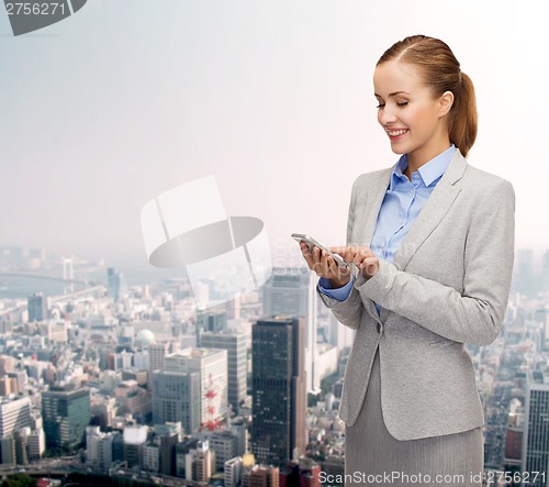 Image of young smiling businesswoman with smartphone