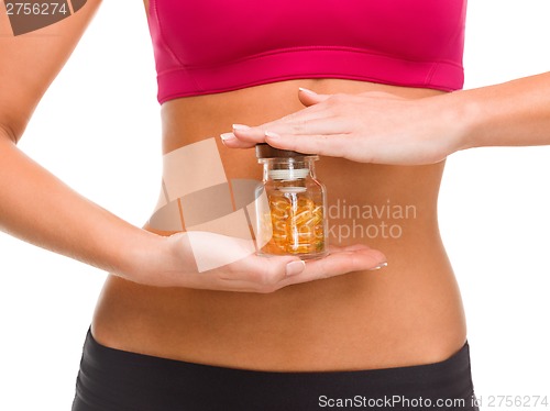 Image of close up of female hands with bottle of capsules