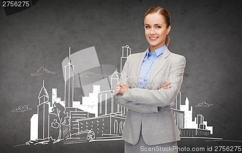 Image of young smiling businesswoman with crossed arms