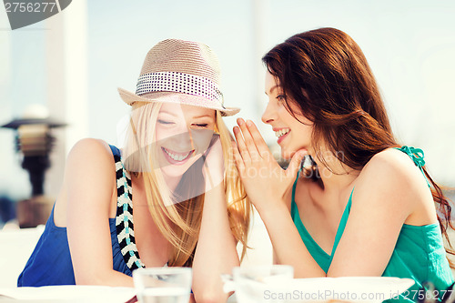 Image of girls gossiping in cafe on the beach