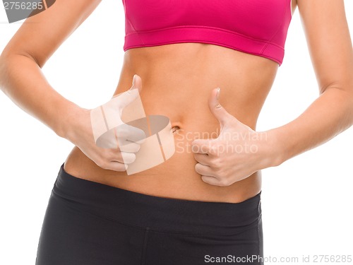 Image of close up of female abs and hands showing thumbs up