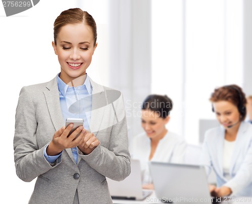 Image of young smiling businesswoman with smartphone