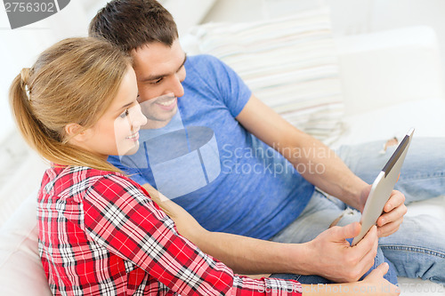 Image of smiling happy couple with tablet pc at home