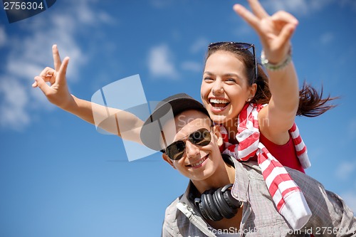 Image of smiling teenagers in sunglasses having fun outside