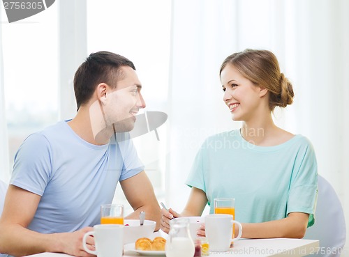 Image of smiling couple having breakfast at home