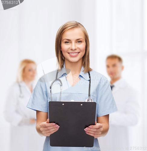 Image of smiling female doctor or nurse with clipboard