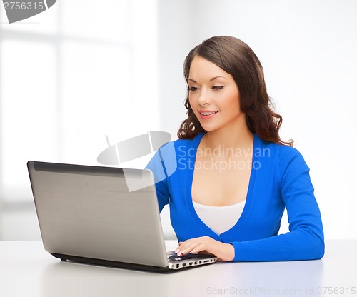 Image of smiling woman in blue clothes with laptop computer