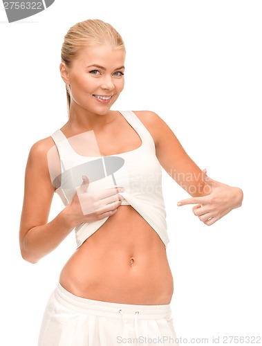 Image of beautiful sporty woman pointing at her abs