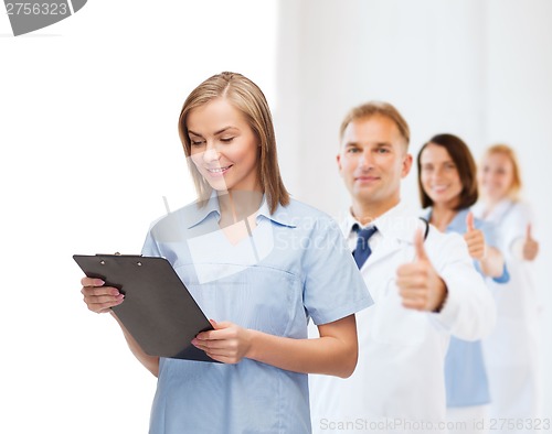 Image of smiling female doctor or nurse with clipboard