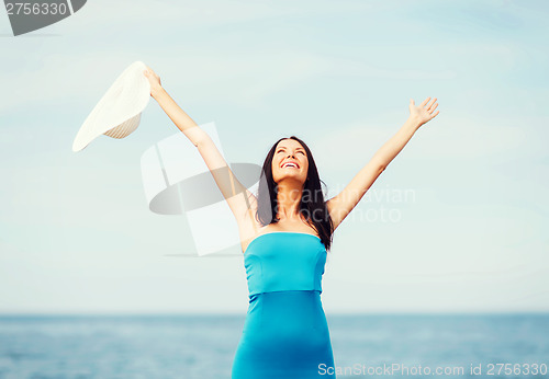 Image of girl with hands up on the beach