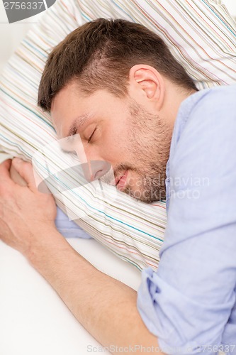 Image of calm young man lying on sofa at home