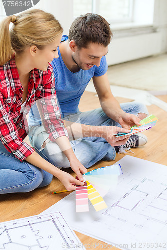 Image of smiling couple looking at color samples at home