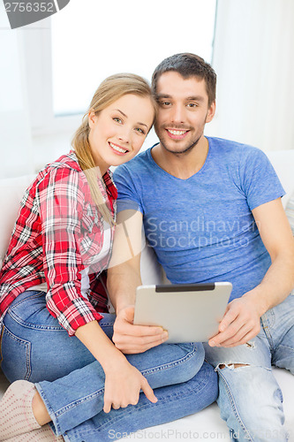 Image of smiling happy couple with tablet pc at home