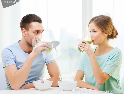 Image of smiling couple having breakfast at home