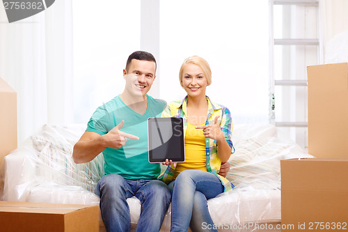 Image of couple relaxing on sofa with tablet pc in new home