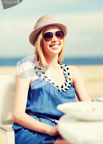 Image of girl in shades in cafe on the beach