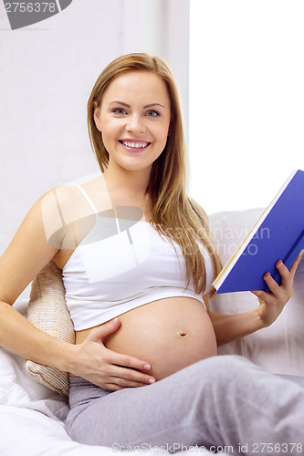 Image of pregnant woman reading book at home