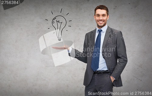 Image of man showing light bulb on the palm of his hand