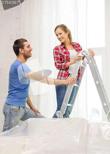 Image of smiling couple hanging curtains