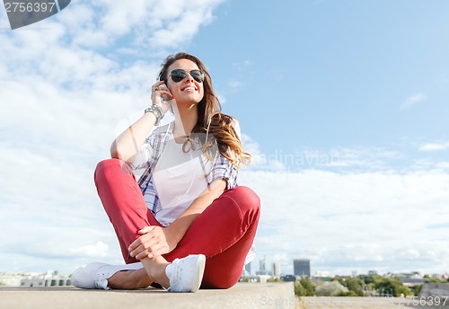 Image of smiling teenage girl in eyeglasses with headphones