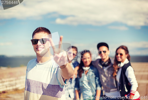 Image of teenage boy with sunglasses and friends outside