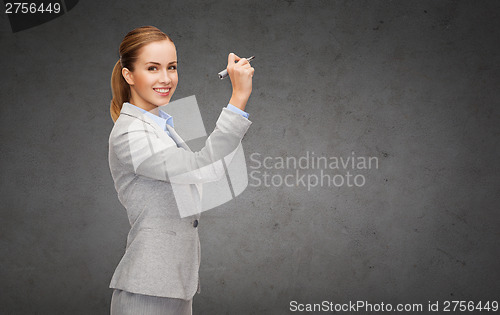 Image of businesswoman writing something in air with marker