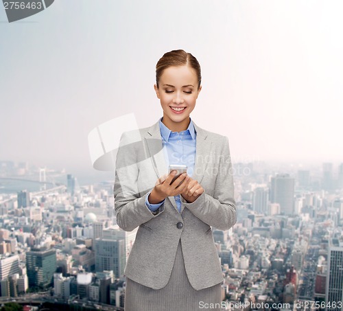 Image of young smiling businesswoman with smartphone