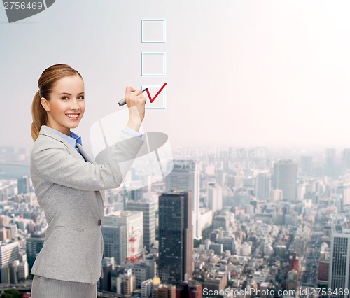 Image of businesswoman writing something in air with marker