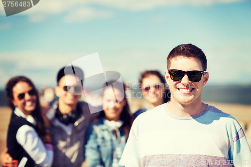 Image of teenager in shades outside with friends