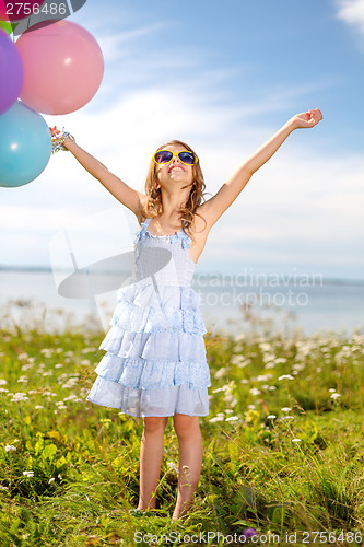Image of happy girl waving hands with colorful balloons