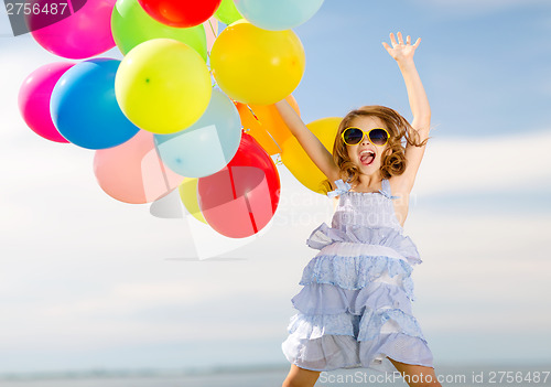 Image of happy jumping girl with colorful balloons