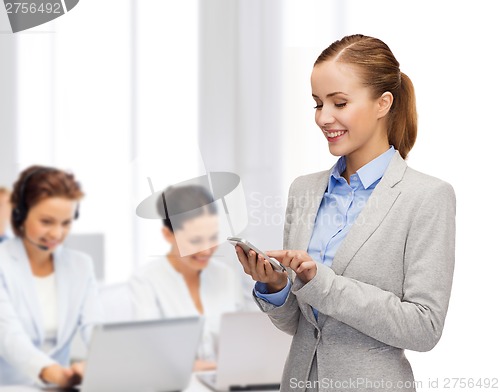 Image of young smiling businesswoman with smartphone