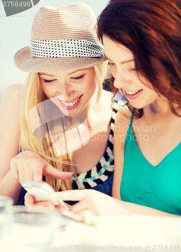 Image of girls looking at smartphone in cafe