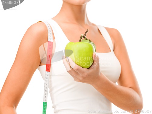 Image of female hand with apple and measuring tape
